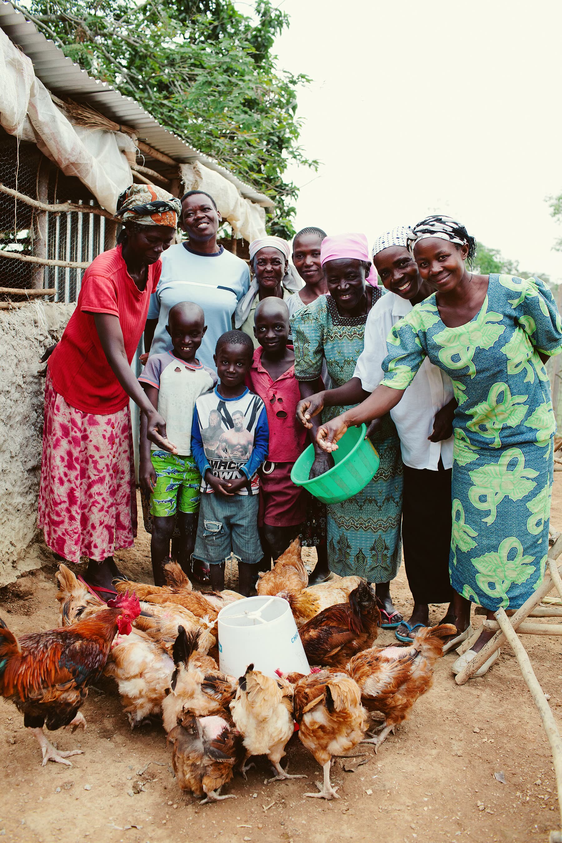 A group of women with their chickens outside a house